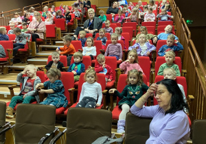 Dzieci siedzące na widowni w oczekiwaniu na rozpoczęcie projekcji filmu.