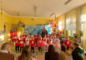 Pani wice dyrektor w otoczeniu dzieci wita rodziców.