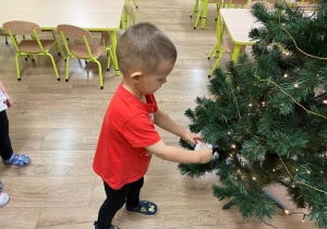Chłopiec ozdabia choinkę