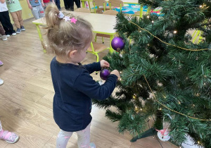 Dziewczynka wiesza ozdoby na choince