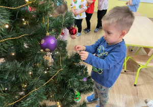 Chłopiec ozdabia choinkę