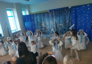 Dziewczynki w strojach aniołków tańczą