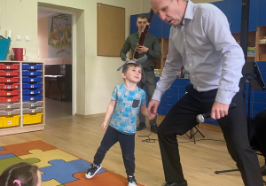 Chłopiec i pan Maciej poruszają się w rytm melodii granej na fagocie.