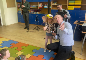 Dziewczynka z kolorowym kapeluszem na głowie odgrywa rolę pani wiosny.