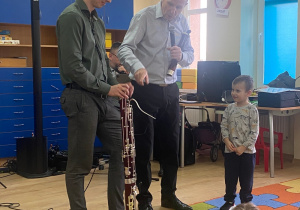 Pan Maciej i jego gość przedstawiają dzieciom wygląd, budowę fagotu.