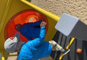 Chłopcy wchodzą do zjeżdżalni.