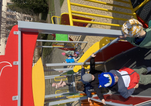 Dzieci pokonują różne elementy w drodze do zjeżdżalni.