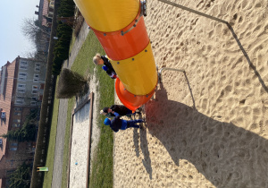 Chłopcy stoją przy wylocie ze zjeżdżalni.