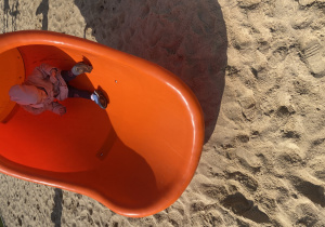 Dziewczynka zjeżdża w zjeżdżalni.