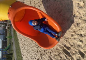 Chłopiec zjeżdża ze zjeżdżalni.