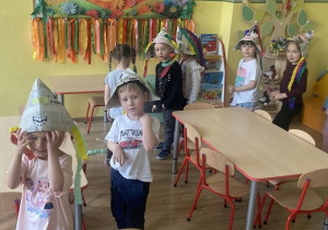 Dzieci prezentują powstałe kapelusze w tanecznym slalomie.
