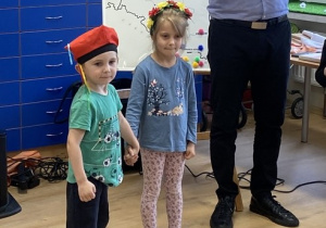 Dziewczynka i chłopiec odtwarzają taniec "Krakowiaczek".