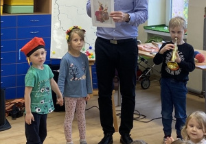 Dziewczynka i chłopiec odtwarzają taniec "Krakowiaczek". Chłopiec "odgrywa hejnał.