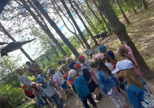 Dzieci oglądają realistyczną, gigantyczną rzeźbę ćmy.