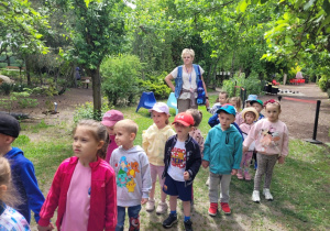 Dzieci idą ścieżką edukacyjną z przewodnikiem