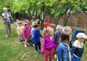 Dzieci idą ścieżką edukacyjną z przewodnikiem