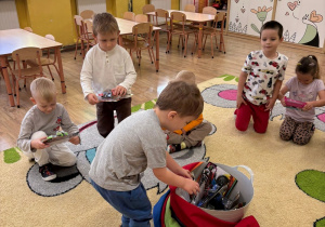 Chłopcy wyjmują prezent.