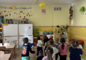Dzieci odbijają balon tak by nie spadła na dywan.