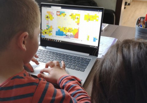 Chłopiec układa puzzle z mapą Polski