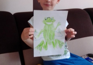 Chłopiec pokazuje narysowaną żabkę