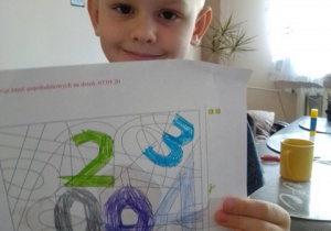 Chłopiec pokazuje pokolorowane cyfry