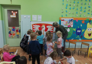 Dzieci wykonują grupową pracę plastyczną - godło Polski