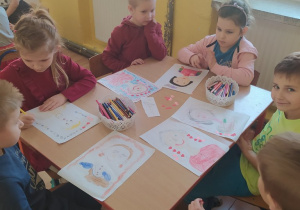 Dzieci rysują kredkami portret babci.