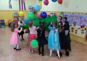 Dzieci na przerwę w muzyce podrzucają balony umieszczone na chuście.