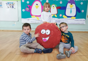 Dwoje dzieci prezentuje wykonanego plastycznego pączka.