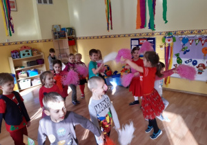 Dzieci tańczą własny układ taneczny z pomponami.