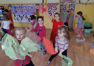 Dzieci tańczą machając chustami do muzyki.