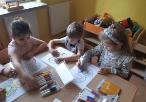 Dzieci malują mandalę w kształcie ósemki.