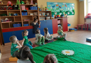 Dzieci poszukują koloru zielonego w sali.