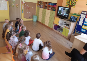 Dzieci słuchają prezentacji na temat zanieczyszczeń miast.