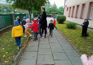 Dzieci porządkują teren przedszkolny.