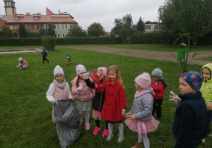 Dzieci pokazują wrzucane śmieci.