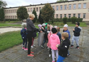 Dzieci porządkują ogród przedszkolny.