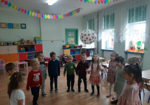 Dzieci bawią się balonem przy muzyce
