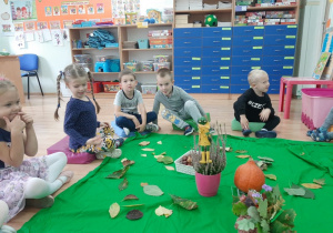 Dzieci siedzą w kole i rozmawiają o jesiennych skarbach