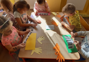 Dzieci przyklejają klawisze pianina