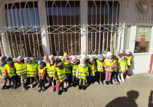 Dzieci stoją przed budynkiem Poczty Polskiej