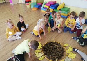 Dzieci układają na podłodze słonecznik.