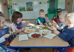Dzieci nakładają owoce na patyczki szaszłykowe