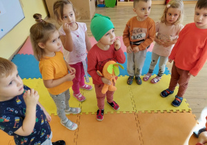 Dzieci stoją na kolorowej macie