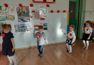 Dzieci trzymają liście w kolorach flagi i tańczą