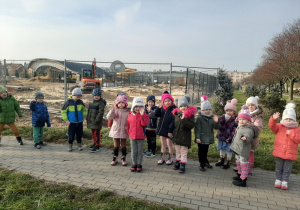 Dzieci na spacerze obserwują prace budowlane