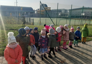 Dzieci stoją przed boiskiem szkolnym