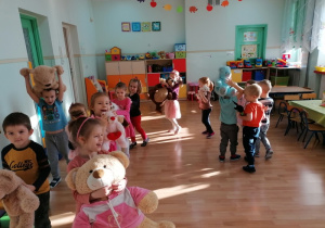 Dzieci tańczą z misiami przy piosence ,,Jadą, jadą misie"