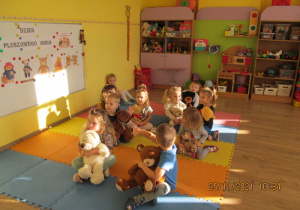 Dzieci siedzą na macie z misiami