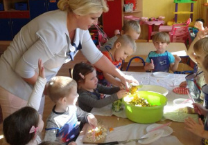 Dzieci mieszają warzywa w misce